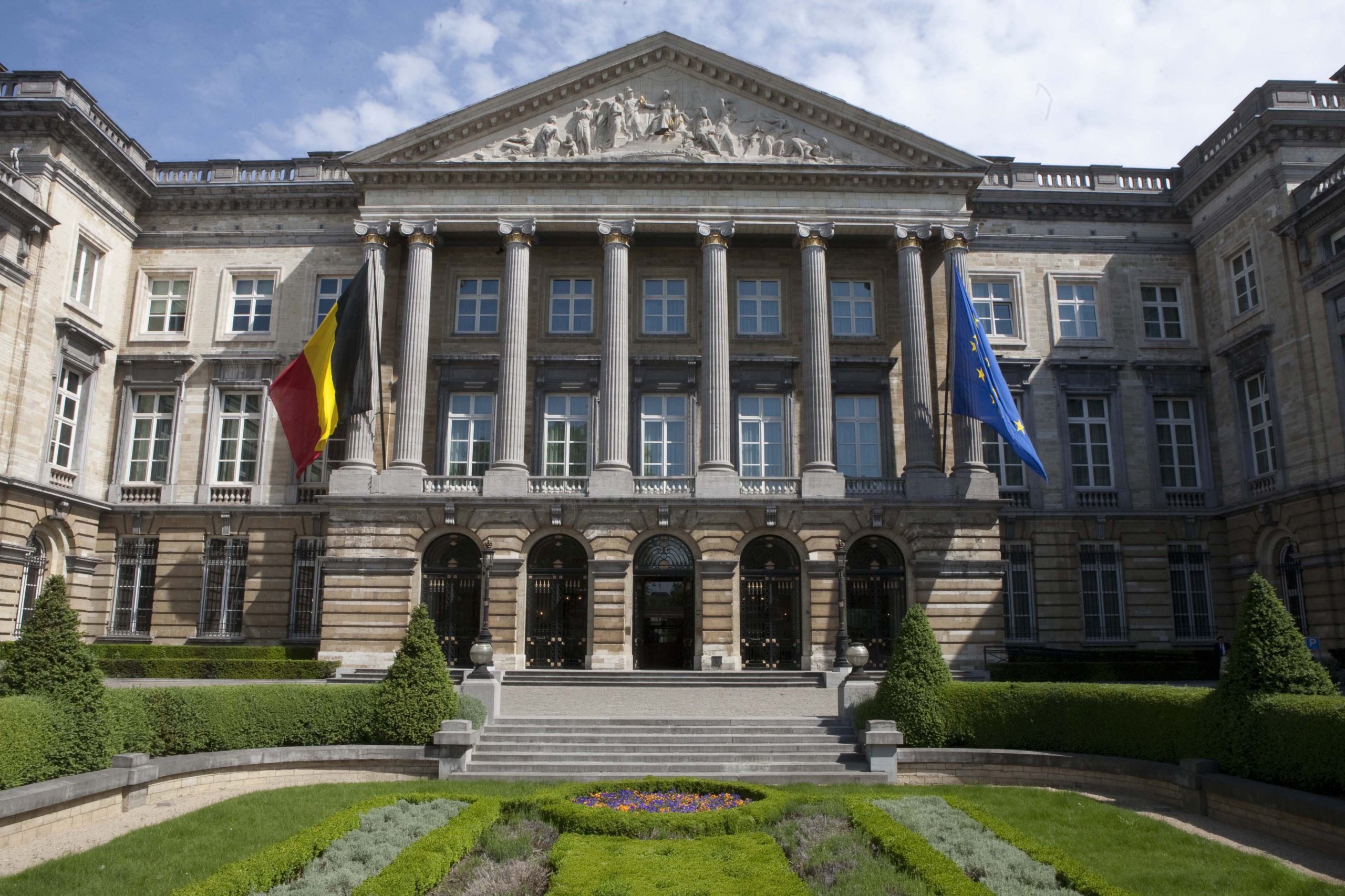 A picture of the Royal palace of Brussels with the Belgian flag and the EU flag.