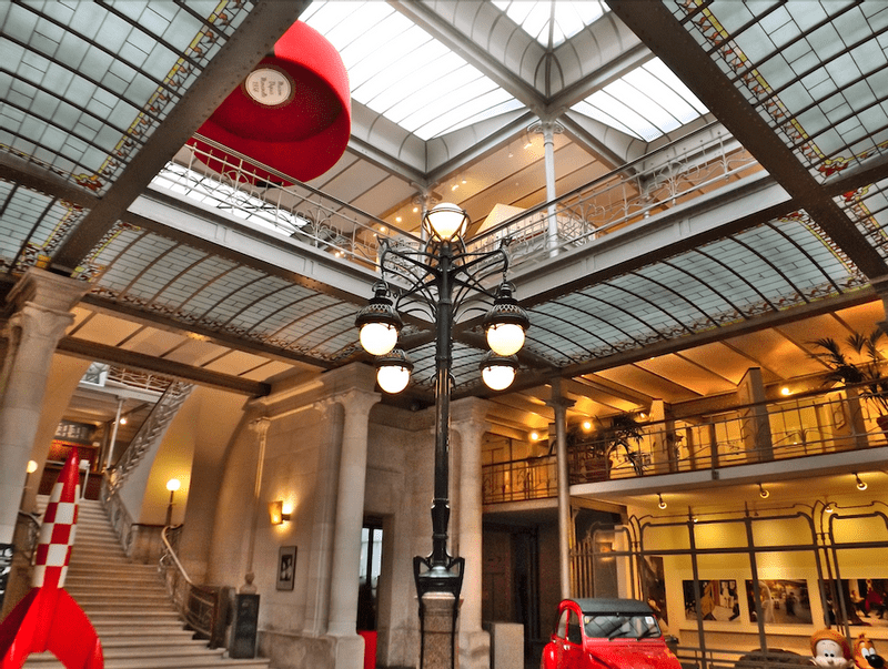 A picture of the Comic Museum from inside. The building is made by Victor Horta. The museum tells people about the history of comics in Belgium. There is a cafe in the museum.